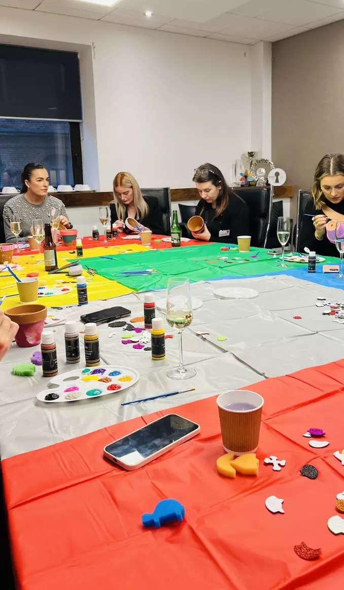 A group of people painting pottery