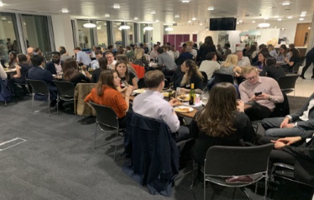 Large room with people relaxing around tables